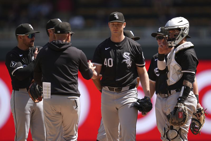 Chicago White Sox starting pitcher Michael Soroka (40) hands the game ball to manager Pedro Grifol during a pitching change in the sixth inning of a baseball game against the Minnesota Twins, Thursday, April 25, 2024, in Minneapolis. (AP Photo/Abbie Parr)