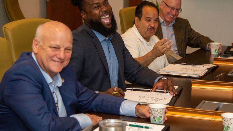 Development Authority of Fulton County board members (left to right) Brandon Beach, Kyle Lamont, Michel Turpeau and Thomas Tidwell share a humorous moment during a meeting in August 2019 at the Fulton County Government Center in Atlanta. School leaders and the city’s development authority want Fulton County to stop handing out tax breaks to development projects located in Atlanta. (Photo by Phil Skinner)