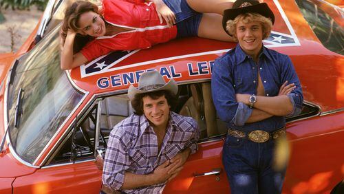 Catherine Bach (Daisy), Tom Wopat (Luke) and John Schneider (Bo) spent a lot of time with the General Lee, which had the Stars and Bars on the roof. CREDIT: CBS