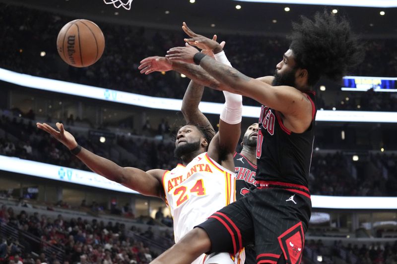 Atlanta Hawks forward Bruno Fernando (24) and Chicago Bulls guard Coby White, right, and center Andre Drummond vie for a rebound during the first half of an NBA basketball play-in tournament game in Chicago, Wednesday, April 17, 2024. (AP Photo/Nam Y. Huh)