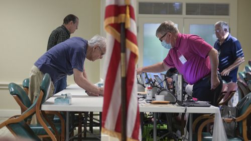 Poll workers assist early voters at Tim D. Lee Senior Center in Marietta on Monday, May 2, 2022. (Natrice Miller / natrice.miller@ajc.com)