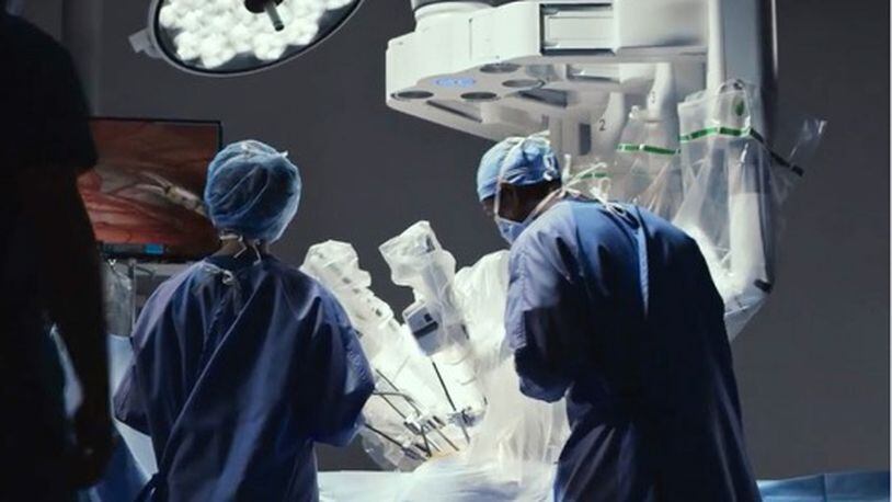 Doctor and surgical assistant working with Intuititive's robotic da Vinci surgical system. (Courtesy Intuitive)
