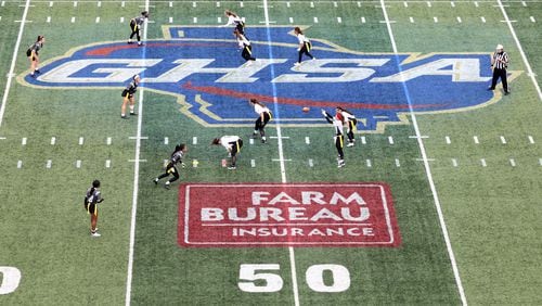 Dec. 28, 2020 - Atlanta, Ga: With the GHSA logo on the field, West Forsyth quarterback Haylee Dornan receives the snap in the first half against Hillgrove during the Class 6A-7A Flag Football championship at Center Parc Stadium Monday, December 28, 2020 in Atlanta, Ga.. JASON GETZ FOR THE ATLANTA JOURNAL-CONSTITUTION



