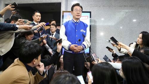 South Korea's main opposition Democratic Party (DP) leader Lee Jae-myung, center, speaks to reporters after watching TV broadcasting results of exit polls for the parliamentary election at the National Assembly on Wednesday, April 10, 2024 in Seoul, South Korea. (Chung Sung-Jun/Pool Photos via AP)