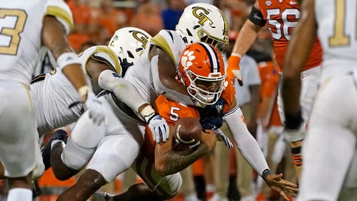 Clemson quarterback D.J. Uiagalelei (5) fumbles as he is hit by Georgia Tech defenders in the second half of an NCAA college football game, Saturday, Sept. 18, 2021, in Clemson, S.C. (AP Photo/John Bazemore)