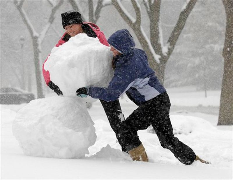 Mary Otto and Maggie Graham build a snowman in Wheaton, Ill., during a snow storm in the suburbs of Chicago, Ill., on Tuesday, March 5, 2013. (AP Photo/Daily Herald, Mark Black)