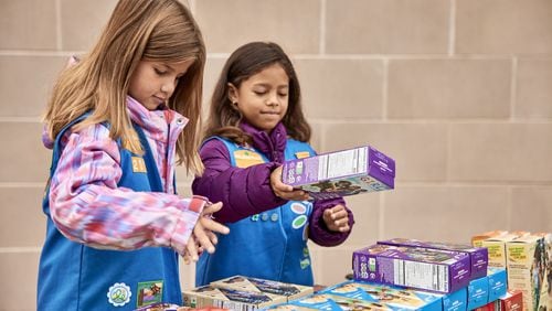 A pair of Girl Scouts from Cherokee County hawk baked goods at a booth sale, including the in-demand Adventureful cookie. Booth sales of Girl Scout Cookies began this month. Photo: Girl Scouts