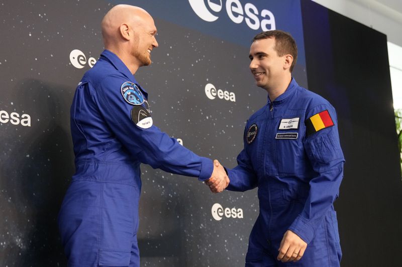 Astronauts crew leader Alexander Geerst, left, hands over the badge to Raphael Liegeois of Belgium at the candidates of the Class of 2022 graduation ceremony at the European Astronaut Centre in Cologne, Germany, Monday, April 22, 2024. ESA astronaut candidates Sophie Adenot of France, Pablo Alvarez Fernandez of Spain, Rosemary Coogan of Britain, Raphael Liegeois of Belgium and Marco Sieber of Switzerland took up duty at the European Astronaut Centre one year ago to be trained to the highest level of standards as specified by the International Space Station partners. Also concluding a year of astronaut basic training is Australian astronaut candidate Katherine Bennell-Pegg, who has trained alongside ESA's candidates. (AP Photo/Martin Meissner)