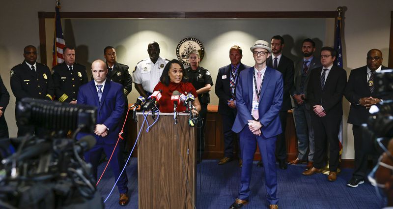 Surrounded by Fulton County law enforcement officials, District Attorney Fani Willis speaks during a press conference about the RICO indictment in the celebrity home invasion ring on Monday, August 29, 2022. (Natrice Miller/ natrice.miller@ajc.com).