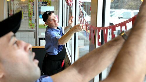 Pratis Boyd, left,  and Eric Hoyle hang Valentine decorations at the Waffle House at Cheshire Bridge Road
 in Atlanta where customers got an opportunity to have a very special
Valentine’s dinner back in 2012.