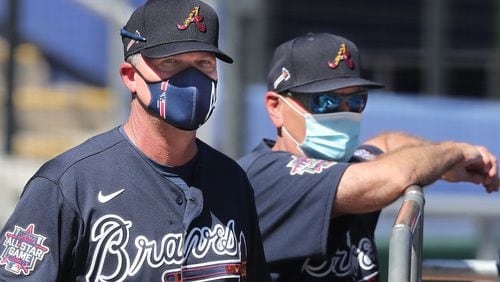 That's Braves Hall of Fame third baseman Chipper Jones behind the mask, along with manager Brian Snitker watching over batting practice at spring training this year. (Curtis Compton / Curtis.Compton@ajc.com)