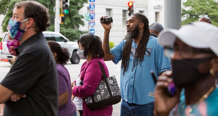 Well known rapper Pastor Troy (in blue) films the body of John Lewis being taken in a hearse from the Georgia State capital for a funeral at Ebenezer Baptist Church on Thursday July 30th, 2020. PHIL SKINNER FOR THE ATANTA JOURNAL-CONSTITUTION