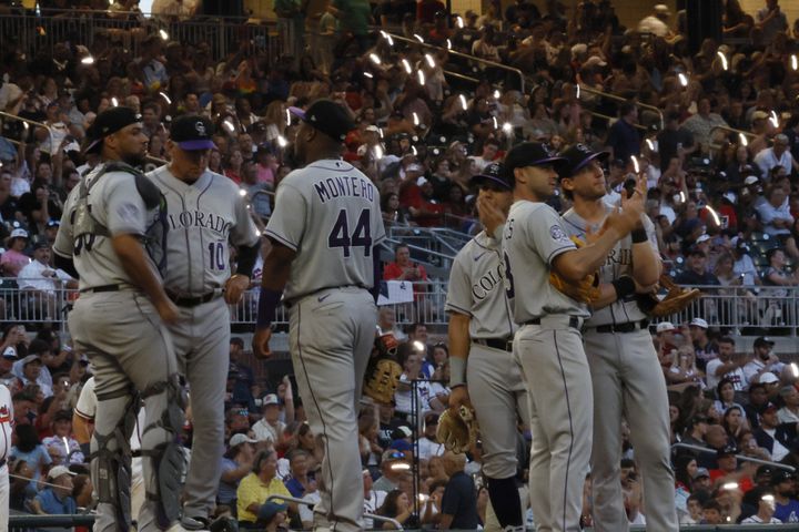 Braves fans perform the tomahawk chop as the Rockies players wait for relief pitcher Matt Carasitito to arrive at the mound during the fifth inning. Miguel Martinez / miguel.martinezjimenez@ajc.com 