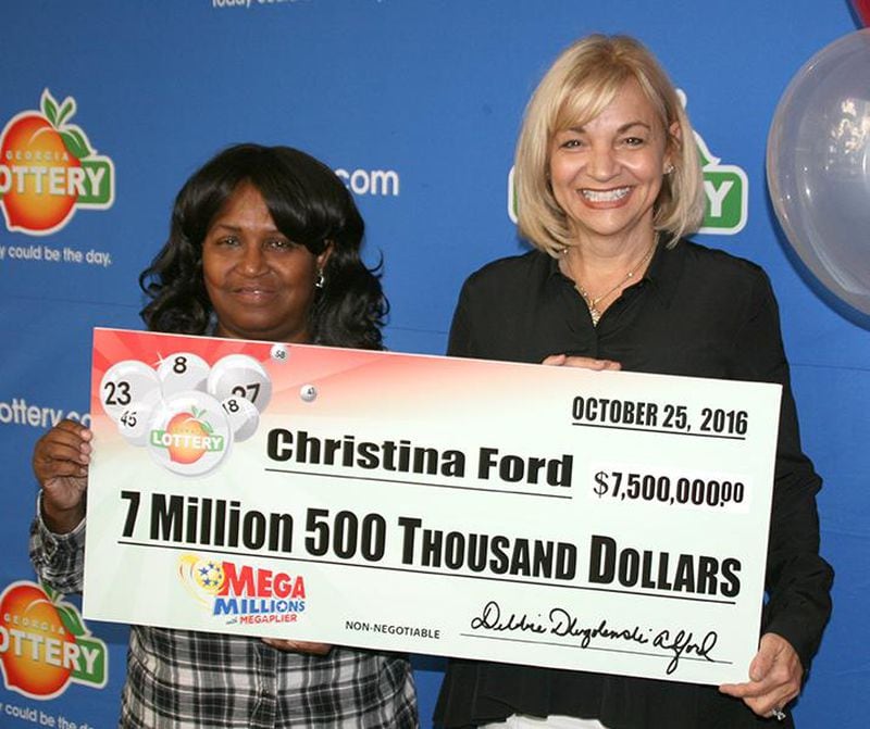 Christina Ford, 64 of Dallas, poses with her $7.5 million lottery check. She split a July jackpot with a winner in Virginia.