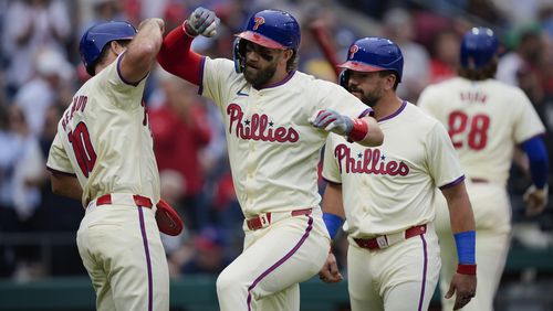 Philadelphia Phillies' Bryce Harper, second from left, celebrates with J.T. Realmuto, left, and Kyle Schwarber, front right, after hitting a three-run home run off San Francisco Giants pitcher Mason Black during the fifth inning of a baseball game, Monday, May 6, 2024, in Philadelphia. (AP Photo/Matt Rourke)
