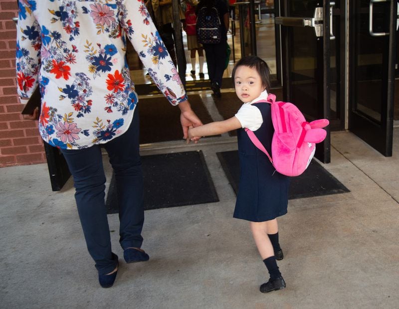 Para-pro Shaniqua Layne walks Kayla Tran into James Jackson Elementary on the first day of school Monday, August 6, 2018, in Jonesboro.