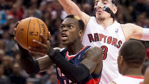 Atlanta Hawks guard Dennis Schroder, left, drives to the net past Toronto Raptors guard Nando de Colo, right, during the second half of an NBA basketball game in Toronto on Sunday, March 23, 2014. (AP Photo/The Canadian Press, Nathan Denette)