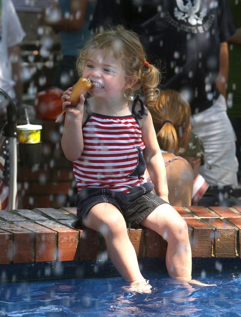 July 4, 2009: Kit Waldrep, 3, of Smyrna eats a corn dog while cooling her feet in the fountain after watching the Marietta Freedom Parade.