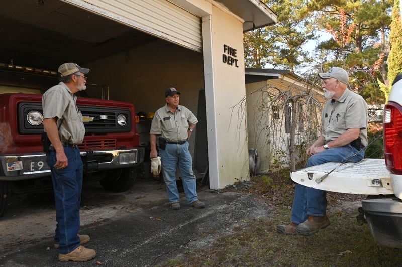 Glascock County Road Department employees (from left) Vance Black, 67, Roger Coxwell, 73, and Melvin Black, 71, take a break while working on replacing batteries on the only fire engine at the fire department next to the city hall in Edgehill, the smallest incorporated city in Georgia. They are all former Edgehill residents. (Hyosub Shin / Hyosub.Shin@ajc.com)