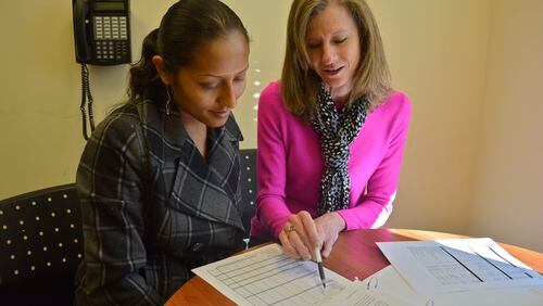 Jennifer Ignacio (left), with volunteer coach Robin Ryder, participates in Buckhead Christian Ministry's money management course that teaches low- income families how to manage their finances, get out of debt and save to receive financial stability.