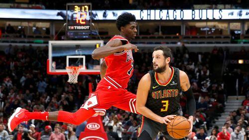 Hawks guard Marco Belinelli (3) gets Chicago Bulls guard Justin Holiday off his feet. The Bulls won 91-86. (AP Photo/Charles Rex Arbogast)