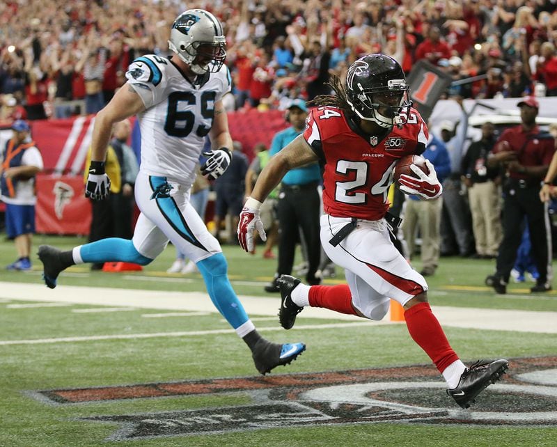 122815 ATLANTA: Falcons running back Devonta Freeman gets past Panthers Jared Allen for a touchdown to tie the game 7-7 during the second quarter in a football game on Sunday, Dec. 27, 2015, in Atlanta. Curtis Compton / ccompton@ajc.com