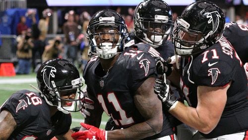 Falcons wide receiver Julio Jones celebrates his first touchdown catch against the Buccaneers with Taylor Gabriel and Wes Schweitzer on a pass from Mohamed Sanu Sunday, November 26, 2017, in Atlanta.