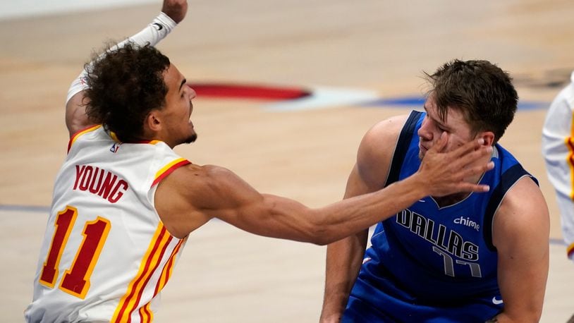 Atlanta Hawks' Trae Young (11) fouls Dallas Mavericks' Luka Doncic (77) by delivering a hand to the face as Doncic works to the basket in the second half of an NBA basketball game in Dallas, Wednesday, Feb. 10, 2021. (AP Photo/Tony Gutierrez)