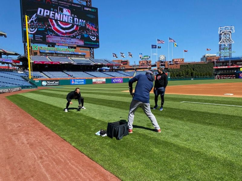 Braves first baseman Matt Olson takes fielding practice from third-base coach Matt Tuiasosopo prior to opening day in Philadelphia March 29, 2024. Third baseman Austin Riley looks on. (AJC photo by Ken Sugiura)