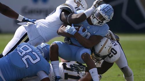 North Carolina running back Jordon Brown (2) is tackled by Georgia Tech linebacker Brant Mitchell (51) and Georgia Tech defensive back Lawrence Austin (20) in the first half of an NCAA college football game Saturday, Sept. 30, 2017, in Atlanta. (AP Photo/John Bazemore)