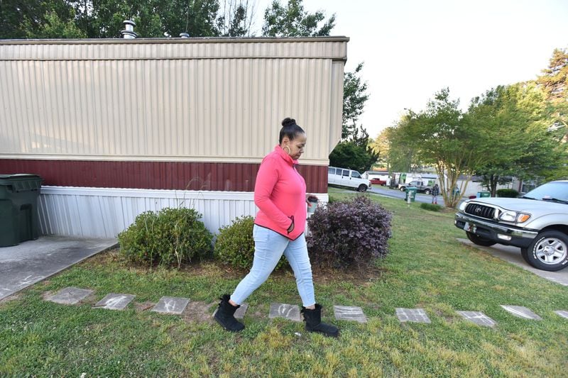 Priscilla Vetaw walks outside her Smoke Creek manufactured home to a nearby school bus stop. Trailers in the park rent for as much as $1,250 per month. HYOSUB SHIN / HSHIN@AJC.COM