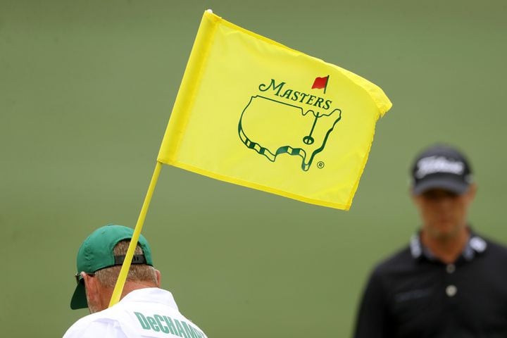 April 10, 2021, Augusta: Bryson DeChambeau’s caddie Tim Tucker holds the pin flag on the second hole during the third round of the Masters at Augusta National Golf Club on Saturday, April 10, 2021, in Augusta. Curtis Compton/ccompton@ajc.com