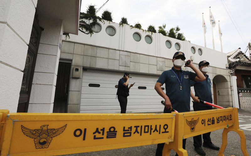 Police officers stand guard in front of the house of Seoul Mayor Park Won-soon.