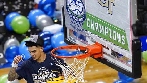 Georgia Tech guard Michael Devoe (0) holds his piece of the net as he celebrates his team's 80-75 win over Florida State in the Championship game of the Atlantic Coast Conference tournament in Greensboro, N.C., Saturday, March 13, 2021. (AP Photo/Gerry Broome)