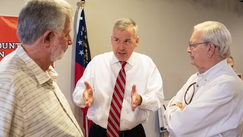 U.S. Rep. Rob Woodall, center, discusses the issues with constituents during a campaign event earlier this year. (CREDIT: Dustin Chambers)