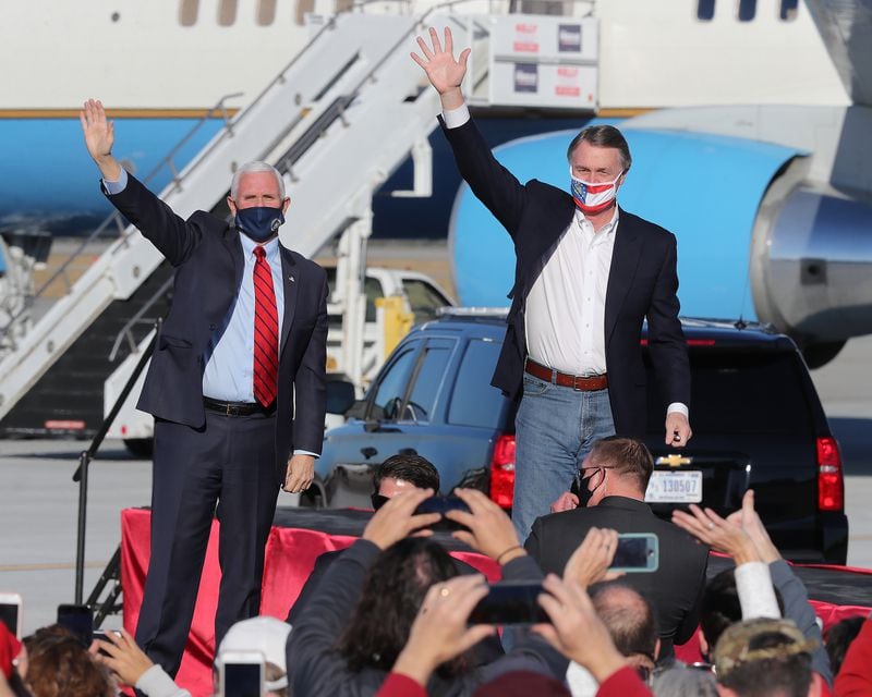 Former U.S. Sen. David Perdue, right, shown with then-Vice President Mike Pence during a campaign stop in December 2020, is considering a challenge against Gov. Brian Kemp in the GOP primary. Perdue has told friends he fears Kemp can’t pull off a repeat win against his Democratic opponent in 2018, Stacey Abrams. (Curtis Compton/Atlanta Journal-Constitution/TNS)