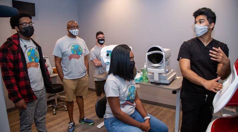 Kevin Freeman, Ryan Cox, Leonard Russell & LaShanta Cox (left to right) listen to Thasin Wahid explain an eye test machine at First Class Eye Care in Duluth. Ryan Cox founded the nonprofit Gwinnett Chatt Outreach last year that mostly donates food and other supplies and furthers community relations with the police. But one of its programs is called "Bridging the Gap," where he takes a group of high school students around to different businesses around Gwinnett County to show them different career opportunities. 
PHIL SKINNER FOR THE ATLANTA JOURNAL-CONSTITUTION.