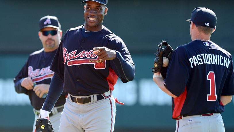 Former Braves first baseman Fred McGriff smiles as he talks with infielder Tyler Pastornicky during spring training in 2013. HYOSUB SHIN / HSHIN@AJC.COM