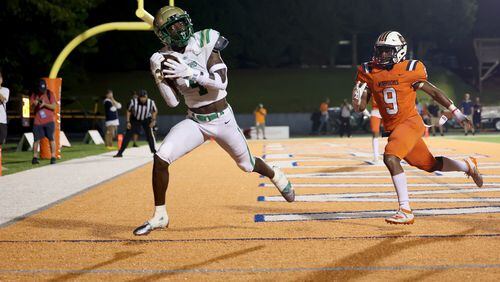 Buford wide receiver Tobi Olawale (4) pulls in the catch for a touchdown against North Cobb defensive back Caleb Jenkins (9) during the second half of Friday's game in Kennesaw. Buford prevailed 35-27. (Jason Getz/Special to the AJC)