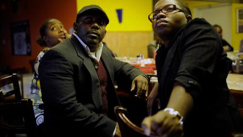 From left, Haitians Kevin Jeudy, 32, of Alpharetta, and Fabiola Guerrier, 26, of Conyers, watch news coverage of the magnitude 7 earthquake that hit their home yesterday at Cafe Fasika in Clarkston, Ga Wednesday, Jan 13, 2010. Guerrien says she came to the United States in 2000 and is still waiting to hear from her family who is still living there.
