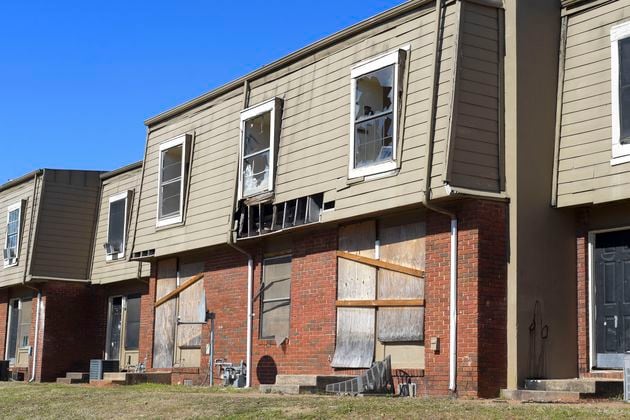 FILE: Broken windows and missing siding are a common site at the Forest Cove apartment complex seen Tuesday, Feb. 1, 2022. (Daniel Varnado/For the Atlanta Journal-Constitution)