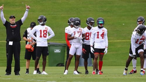 Atlanta Falcons head coach Dan Quinn gives his wide receivers group a double thumbs up as they run receiving routes for the quarterbacks on the first day of mandatory minicamp on Tuesday, June 12, 2018, in Flowery Branch.  Curtis Compton/ccompton@ajc.com