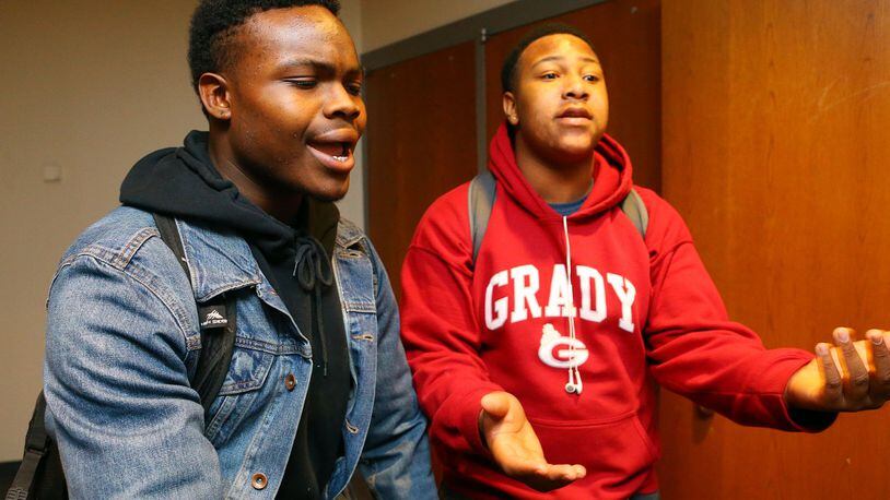 Running back Martin Fleming Jr., (left) and defensive lineman Bomani Branson react after Atlanta Superintendent Erroll Davis announces results of an investigation into fraud and football recruiting violations at Grady High School on Wednesday, March 5, 2014, at Grady High School in Atlanta.