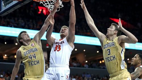 Virginia's Jack Salt (33) shoots between Georgia Tech's Ben Lammers (44) and Evan Cole (3) during the first half of an NCAA college basketball game Wednesday, Feb. 21, 2018, in Charlottesville, Va. (Zack Wajsgras/The Daily Progress via AP)