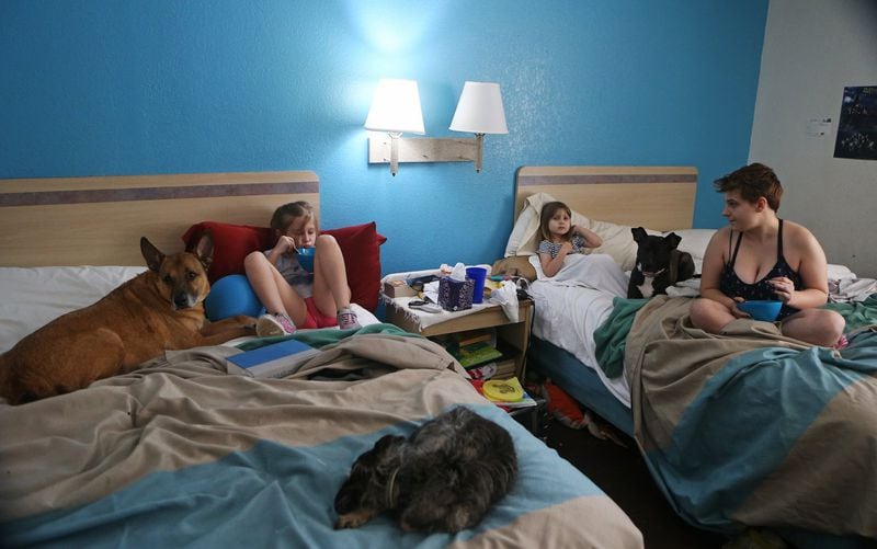Sarah (left), Elizabeth (middle) and Makala (right) Schroeder eat lunch in their room at Motel 6. They live there with their parents and their three dogs. CHRISTINA MATACOTTA / CHRISTINA.MATACOTTA@AJC.COM