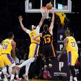 Los Angeles Lakers' Anthony Davis (3) blocks a shot by the Atlanta Hawks' Bogdan Bogdanovic (13) during the first half of an NBA basketball game in Los Angeles Monday, March 18, 2024.  Los Angeles won 136-105. (AP Photo/Damian Dovarganes)