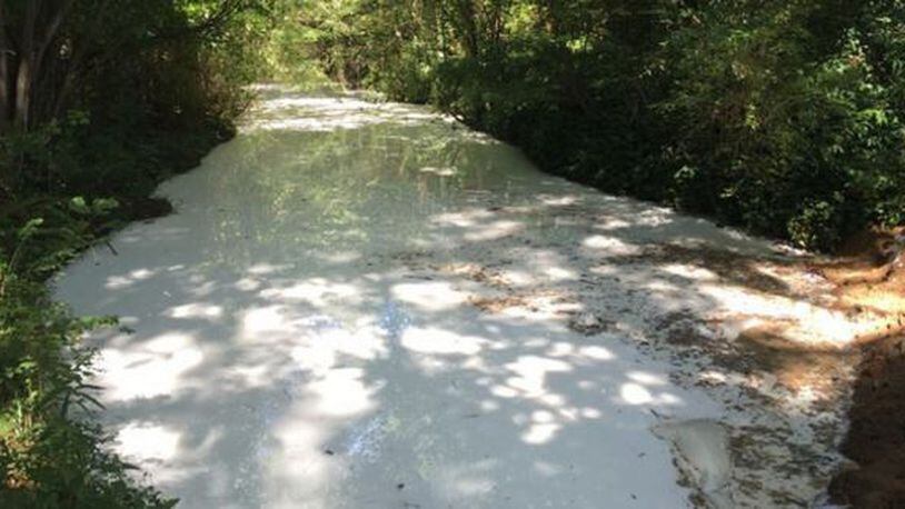 This Cobb County creek water turned white Saturday after 2,300 gallons of a solvent spilled into it. (Credit: Channel 2 Action News)