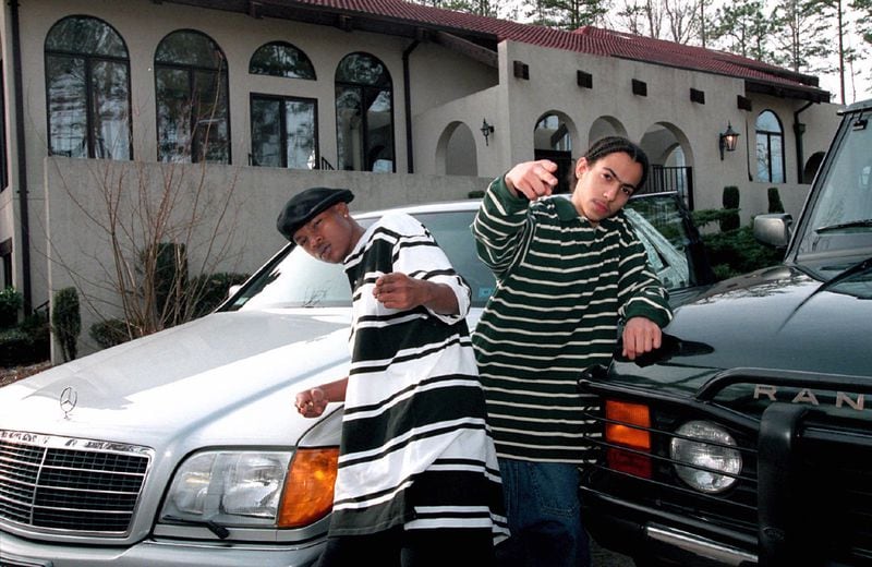 In this Atlanta Journal-Constitution photo taken Jan 21, 1995, Chris Kelly and Chris Smith of the group Kriss Kross, pose with their new cars outside Chris Kelly's home in Fayette County, Ga.