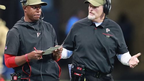 Falcons assistant coach Raheem Morris (left) confers with coach Dan Quinn during a November game against Tampa Bay last season. (Curtis Compton/ccompton@ajc.com)