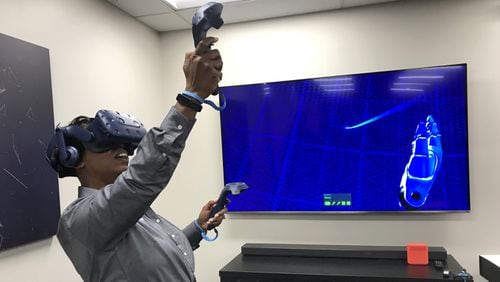 Systems analyst Jan Alexander-Tingle works with an HTC Vive virtual reality system at the unveiling of a new innovation lab at Lockheed Martin’s Orlando facility on Tuesday. (Marco Santana/Orlando Sentinel/TNS)